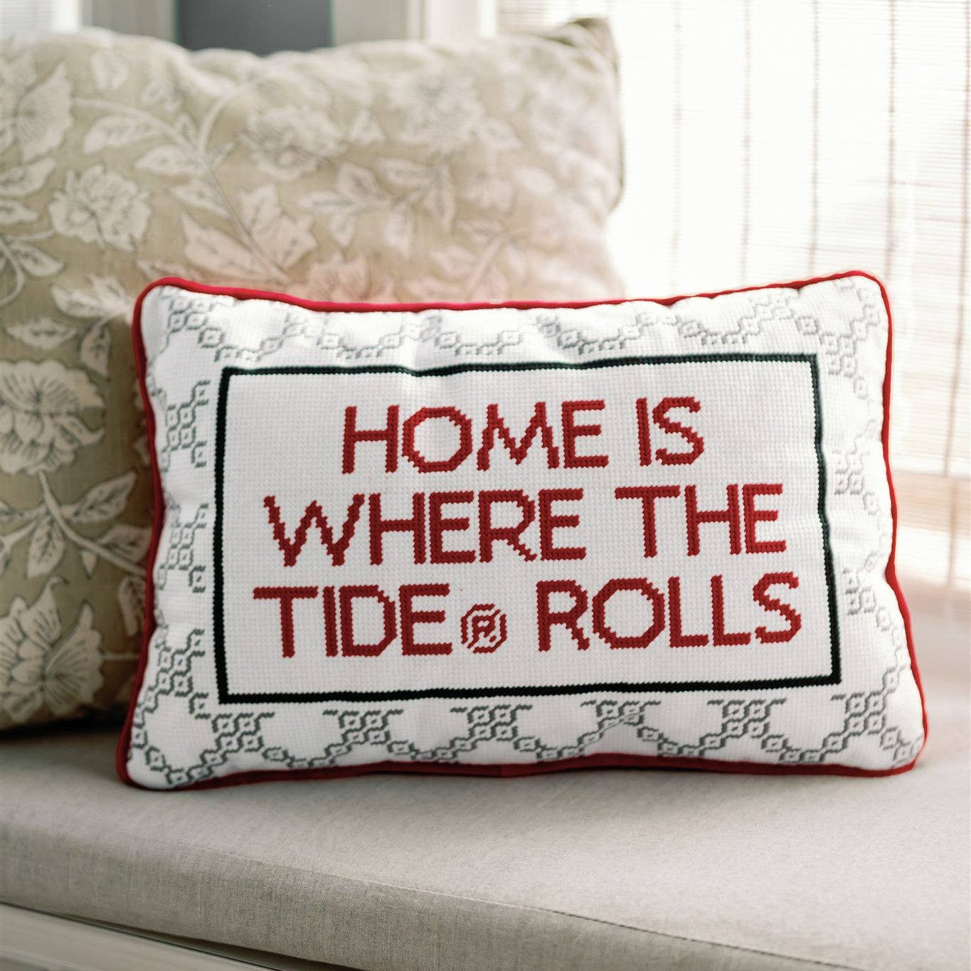 Decorative pillow with 'Home is where the tide rolls' text on a couch.