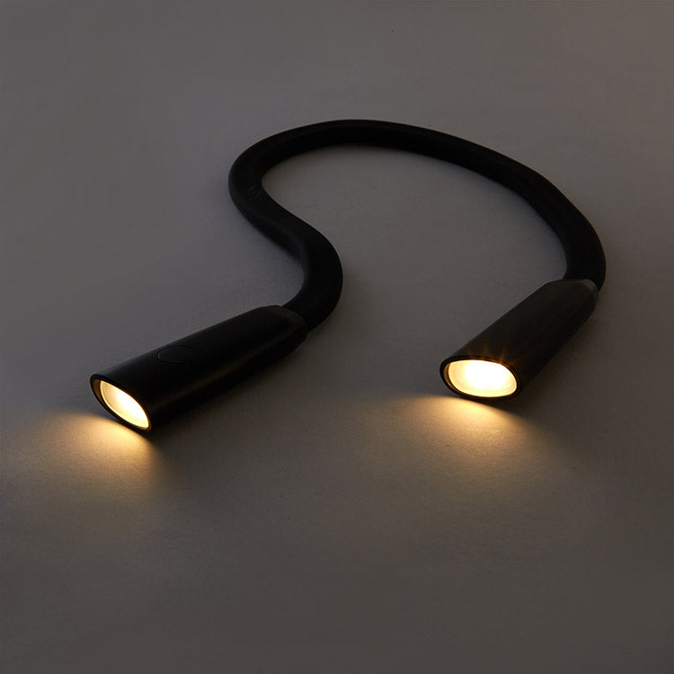 Flexible gooseneck hands-free book light on table with amber light mode on